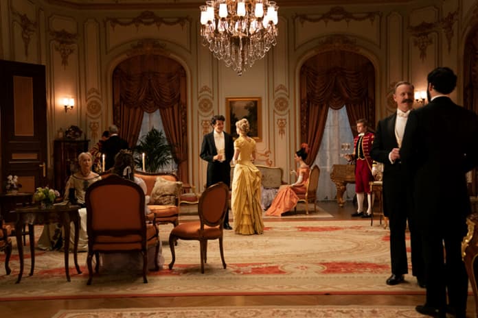 HBO's Gilded Age parlor scene with guests and architect Stanford White