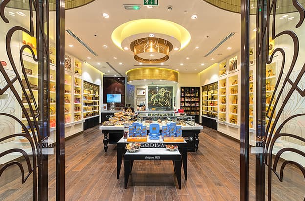 The plush interiors of the store use the enlarged logo of Lady Godiva as a life-size installation as their starting point.